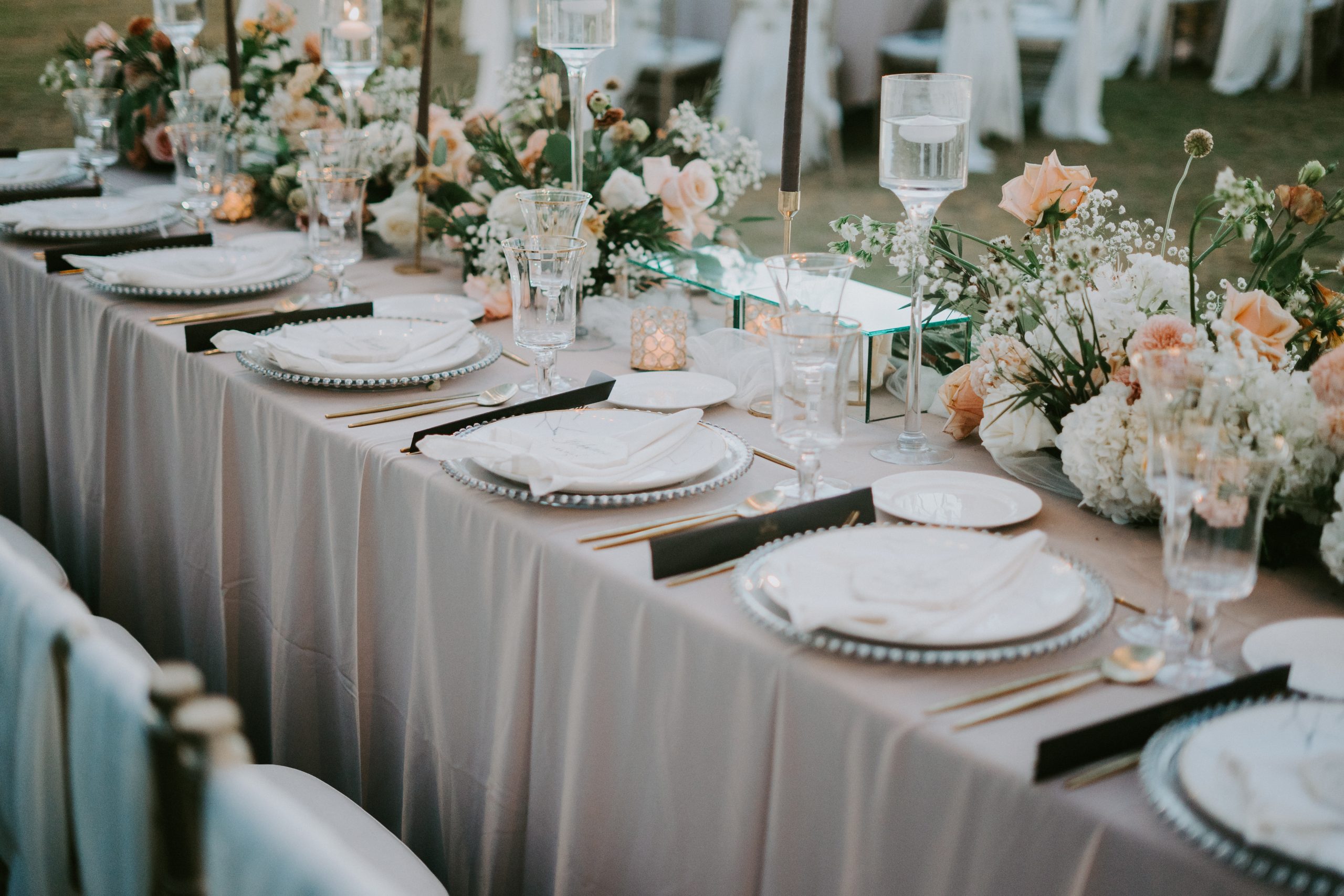 A decorated table setting with a floral design for a wedding celebration during daytime